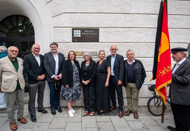 Gruppenbild mit Erinnrungszeichen und Fahne