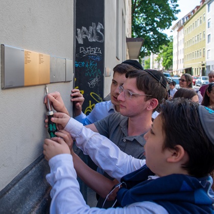 Angehörige bringen Erinnerungszeichen in der Buttermelcherstraße 14 an