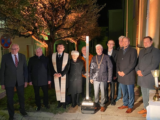 Gruppenfoto vor dem Erinnerungszeichen für Johann Baptist Huber