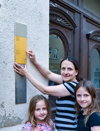 Angehörige mit den Erinnerungszeichen für Mina und Michael Blumenberg