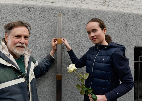 Rick Shulein und eine Schülerin bringen das Erinnerungszeichen für Cäcilie (Cilli) Spatz, geb. Holzer, an