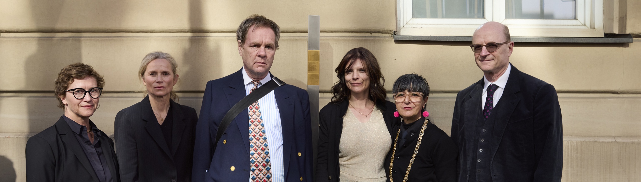 Gruppenfoto vor den Erinnerungszeichen für Familie Helbing